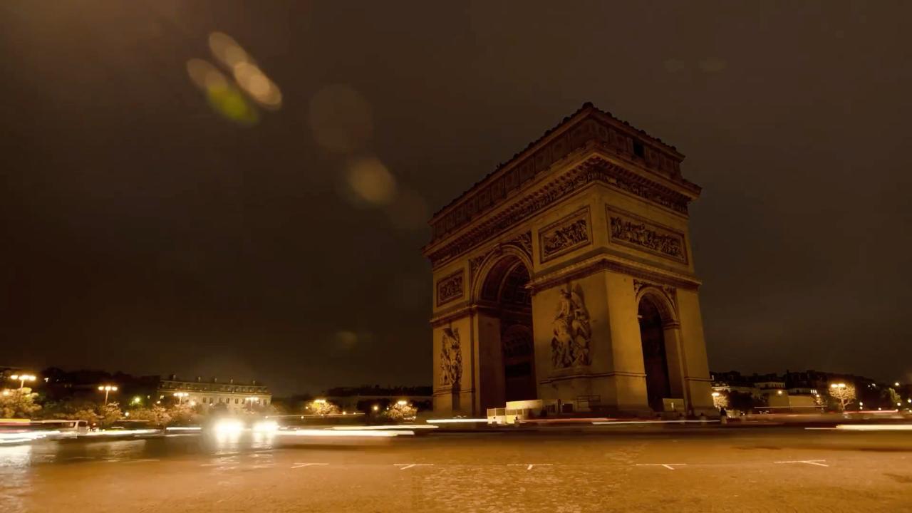 Vue nocturne en time-lapse de l’Arc de Triomphe à Paris, avec les traînées lumineuses de la circulation, évoquant les enjeux de souveraineté numérique européenne.